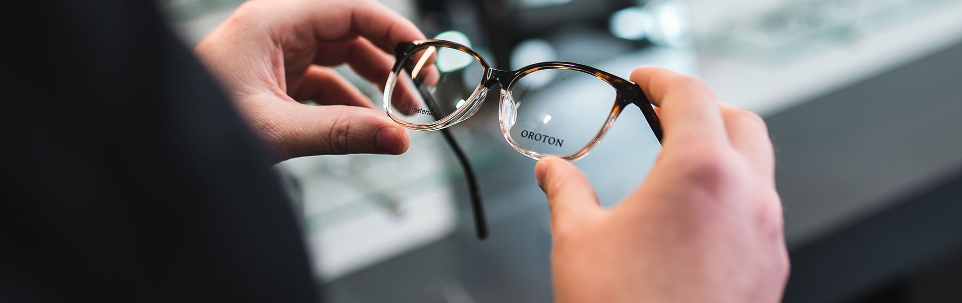 Close up of hands holding a pair of Oroton glasses